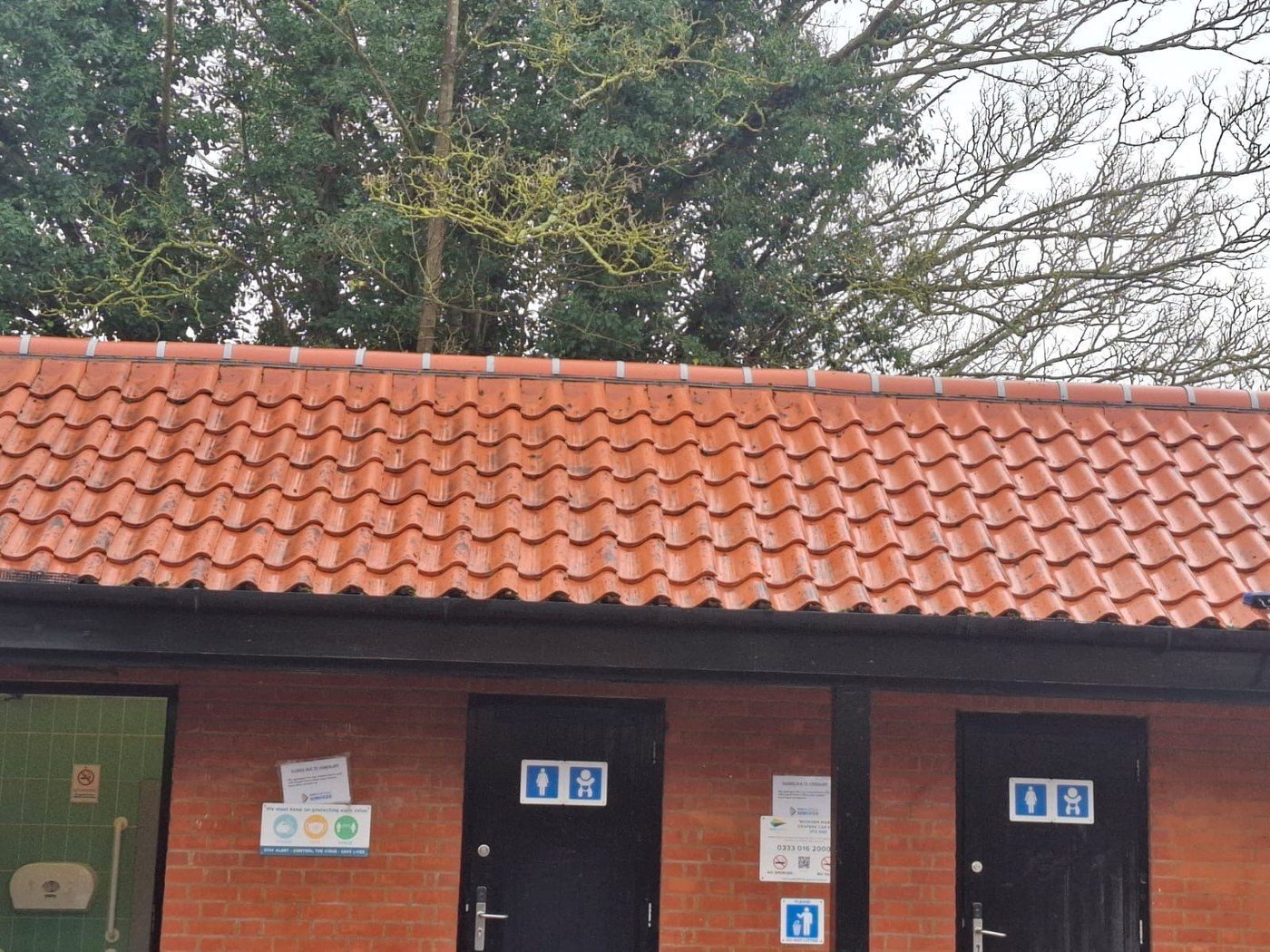 Same toilet block after Eastrada roof clean — moss removed, tiles restored to original red clay finish