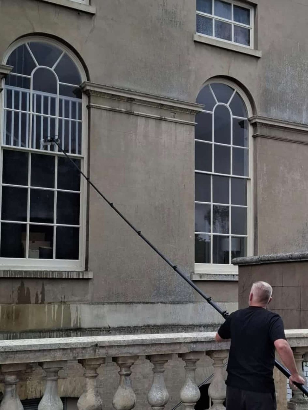 Eastrada operative cleaning sash and arched windows on a Georgian heritage property using a water-fed pole system